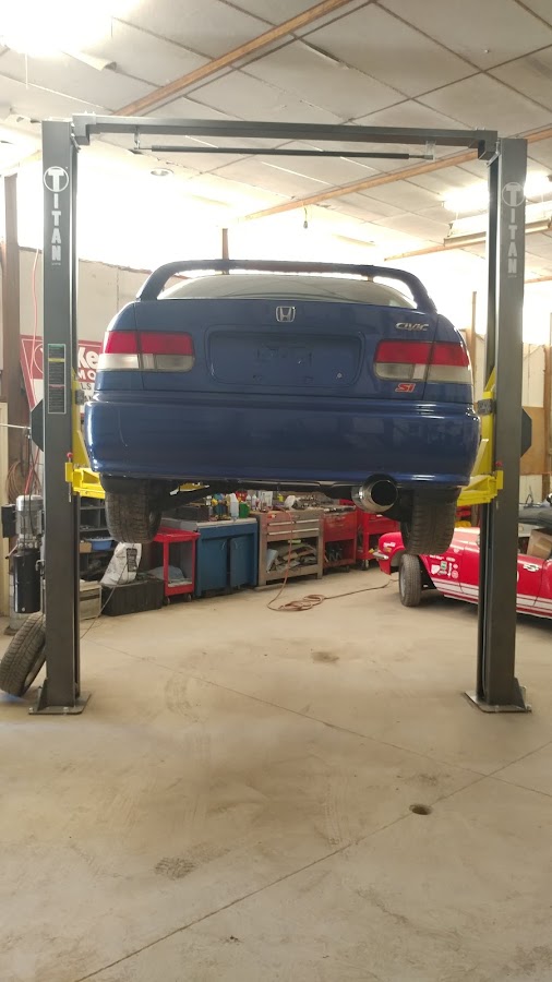 A blue Honda Civic Si up on a two-post lift inside the South Indy Auto Repair shop